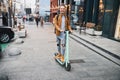 Mirthful young man riding his scooter in the street Royalty Free Stock Photo