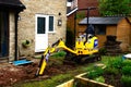 Mini digger parked in garden, UK.