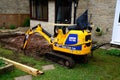 Mini digger excavating ground, UK.