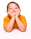 Mischievous and bored child sitting at desk Royalty Free Stock Photo