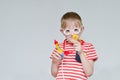 Mischievous boy playing doctor. Toy syringe, glasses and phonendoscope. Portrait Royalty Free Stock Photo