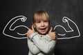 Mischievous child girl showing muscle on black background