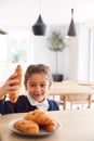 Mischievous Girl Wearing School Uniform Taking Croissant From Kitchen Counter