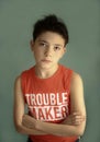 Mischievous teenager boy in trouble maker t-shirt close up sad portrait Royalty Free Stock Photo