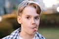 A mischievous teenager makes faces at the camera, sticks out his tongue and indulges. Royalty Free Stock Photo