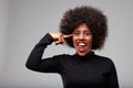 Mischievous trendy young Black woman pointing to her temple Royalty Free Stock Photo