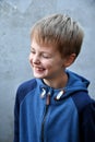 Mischievously laughing schoolboy with blond hair