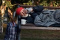 Old man lying on bench in city park in cold weather Royalty Free Stock Photo