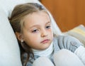 Miserable female child posing in couch at home