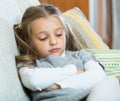 Miserable female child posing in couch at home