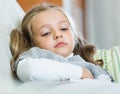 Miserable female child posing in couch at home