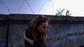 Miserable woman sitting near barb wire, drug addicted in correctional facility Royalty Free Stock Photo