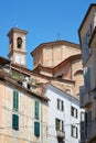 Misericordia church back part in red bricks and old buildings with balcony in a sunny day, blue sky in Mondovi, Italy