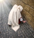 A girl in poor clothes sits on the ground Royalty Free Stock Photo