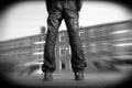 Misfit young man with scattered legs standing in front of a building. Charcoal illustration