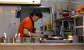 Asian elderly woman cooking food on the kitchen.