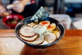 Miso Chashu Ramen: Japanese noodle in Miso soup with chashu pork, boiled egg, dry seaweed and chives in black bowl. Royalty Free Stock Photo