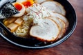 Miso Chashu Ramen: Japanese noodle in Miso soup with chashu pork, boiled egg, dry seaweed and chives in black bowl. Royalty Free Stock Photo