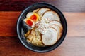 Miso Chashu Ramen: Japanese noodle in Miso soup with chashu pork, boiled egg, dry seaweed and chives in black bowl. Royalty Free Stock Photo