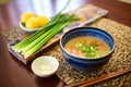 miso paste beside bowl of soup, green onions garnish