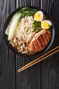 Miso Ramen Asian noodles with egg, duck and pak choi cabbage on dark background closeup. Vertical top view Royalty Free Stock Photo