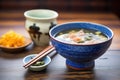 miso soup in ceramic bowl, wooden spoon, soybeans in background Royalty Free Stock Photo