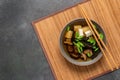 Miso soup. Japanese vegetarian soup with tofu, shiitake mushrooms and seaweed in a bowl on a bamboo mat. Dark grunge