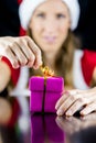 Miss Santa opening a pink wrapped gift box Royalty Free Stock Photo