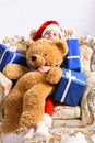 Miss Santa in red hat sits on chic arm chair Royalty Free Stock Photo