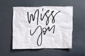 Miss you. Handwritten text on white crumpled paper. Inspirationa