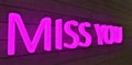 Miss you pink glowing inscription on a plate with a wooden texture. View from the left. The designer will find a use for this. 3d