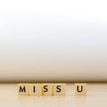 miss you word written in cube on wooden floor on white background