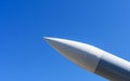 Missile with a warhead pointing at the blue sky in sunlight. Close-up