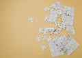 Fragment of a folded white jigsaw puzzle and a pile of uncombed puzzle elements against the background of a blue surface Royalty Free Stock Photo