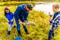 Parent showing kids a dead Pink Salmon after spawning in the Stave River downstream of the Ruskin Dam, Mission, BC, Canada