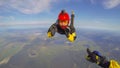 Mission. Parachutist performs an acrobatic trick in the air. Flying men make professional jump.
