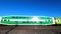 Commuter train passing right to left under clear blue sky.