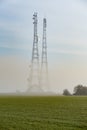 Mist Covered Communication Masts in a field Royalty Free Stock Photo