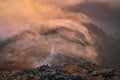 Mist and fog over the top of the hill in mountains evening orange light. autumn mood in hills Royalty Free Stock Photo
