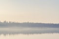 Mist hanging over a quiet lake in the early morning Royalty Free Stock Photo