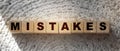 MISTAKES word written on wooden cubes. Business crisis falls and wrong decisions in life concept