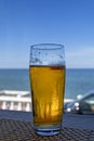 Misted glass of beer in the beach bar on the background of the sea landscape. Sunny day, blue sky and sea Royalty Free Stock Photo