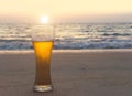 Glass of cold beer on the sea shore at the sunset. Relax on the beach. Royalty Free Stock Photo