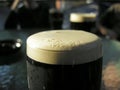 A misted glass of cold dark beer Royalty Free Stock Photo