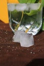 Misted glass of water on a hot Sunny day. juicy Basil, ice and a yellow wall Royalty Free Stock Photo