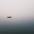 Mistic lonely boat in the middle of the lake, mist fog