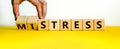 Mistress or stress symbol. Businessman turns wooden cubes and changes the word `mistress` to `stress`. Beautiful yellow table, Royalty Free Stock Photo