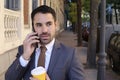 Mistrustful looking businessman answering phone call outdoors Royalty Free Stock Photo