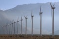 Misty afternoon desert mountains row tall wind turbines