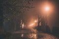 Misty alley in night city park, mystical autumn cityscape with burning lanterns Royalty Free Stock Photo